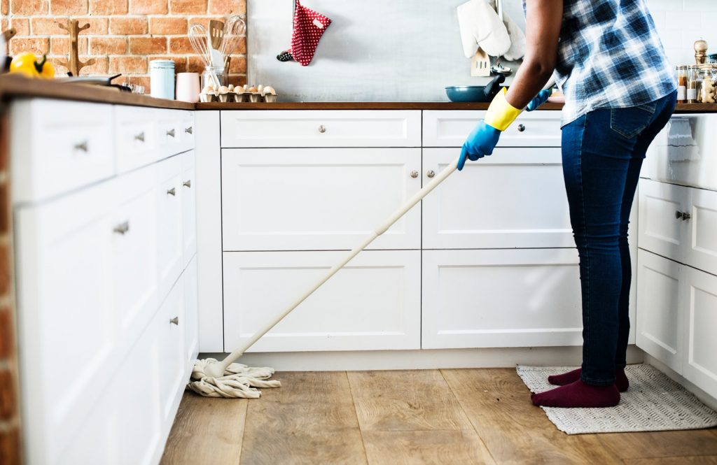 Woman cleaning kitchen with mop