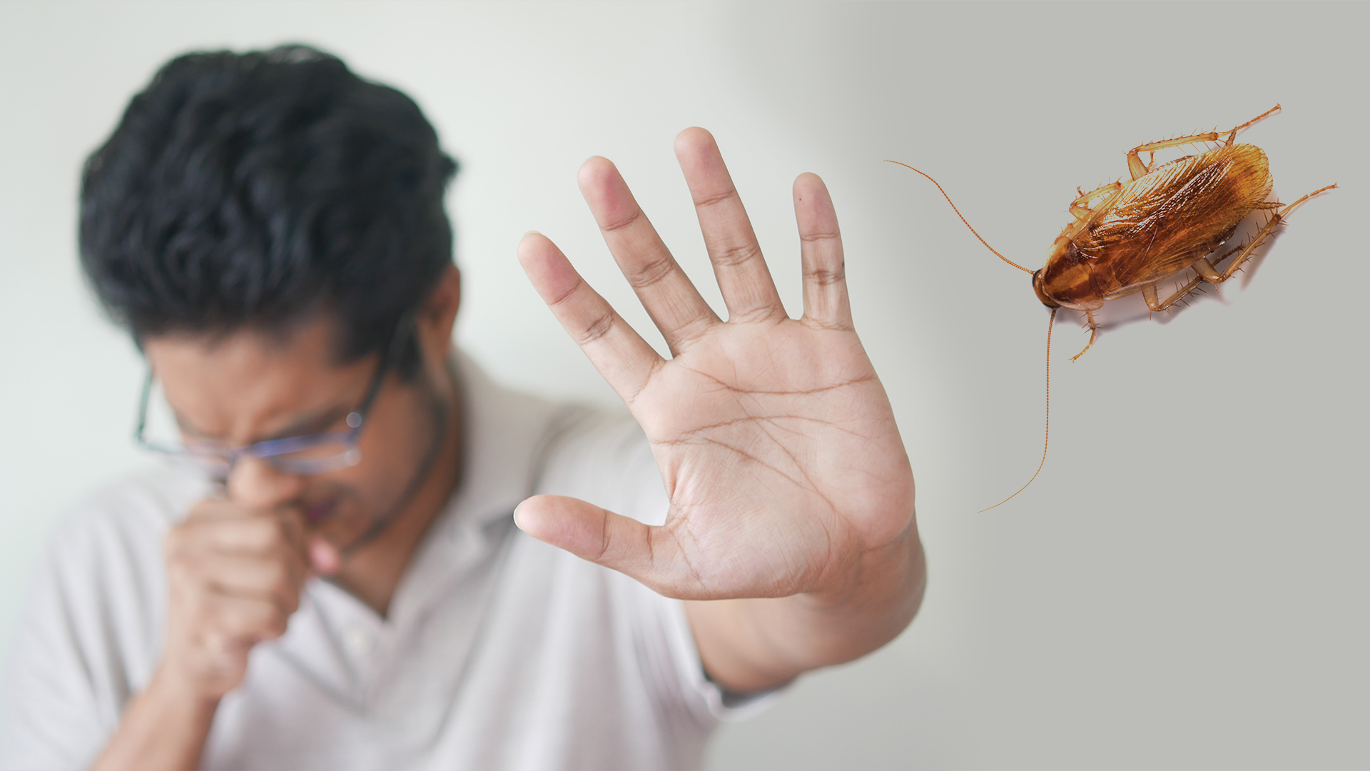Man coughing and holding up his hand next to a cockroach