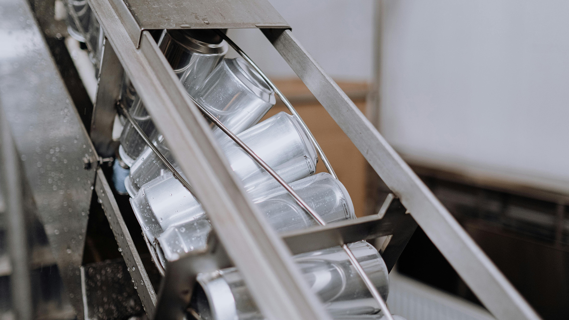 Silver cans in conveyor in a manufacturing plant